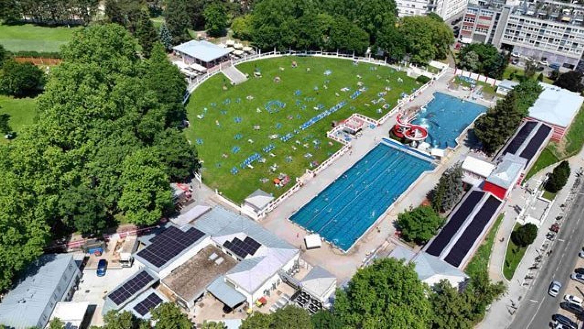 2 Freibad-Becken und eine große, halbkreisförmige Liegewiese.