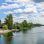 Auf der neuen Donau fährt ein Boot, am linken Ufer ist der terrassenförmige Kagraner Uferplatz.