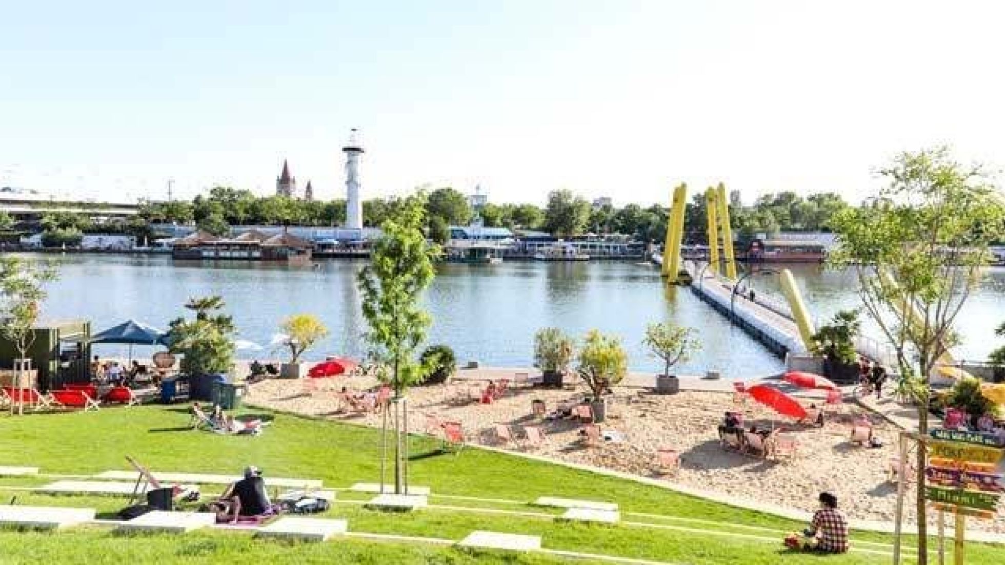 Liegewiese und Sandstrand an der Neuen Donau, auf der anderen Seite des Ufers ist die Donauinsel.