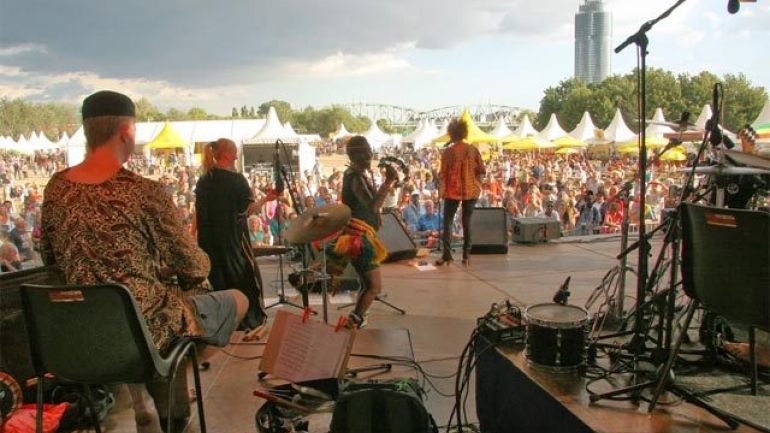 Blick von einer Bühne mit Musikerinnen und Musikern auf Menschenmenge