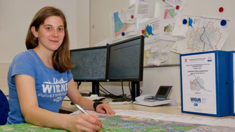 Frau zeichnet etwas in Karte ein