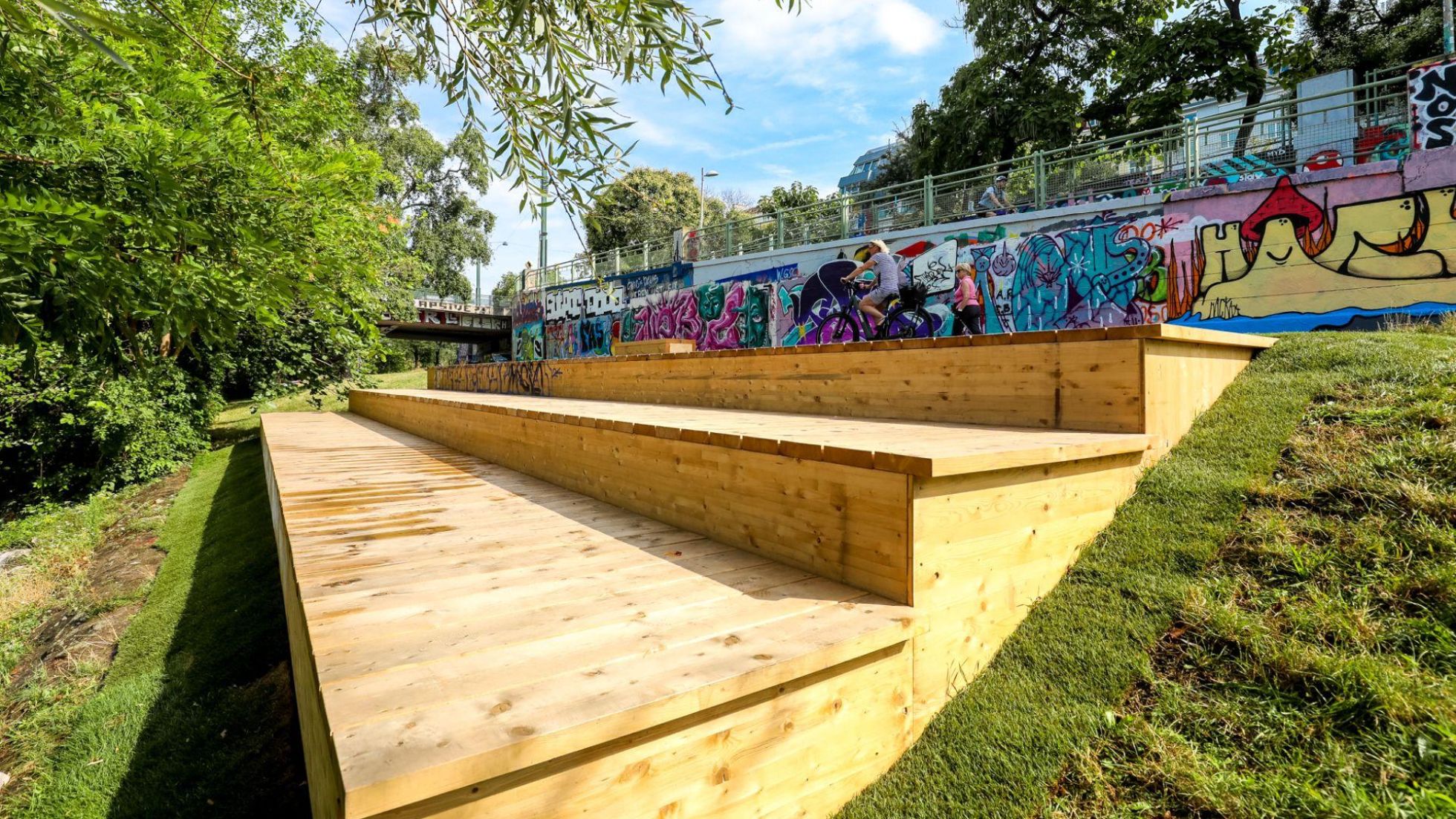 Sitzfläche mit Stufen aus Holz am Ufer des Donaukanals