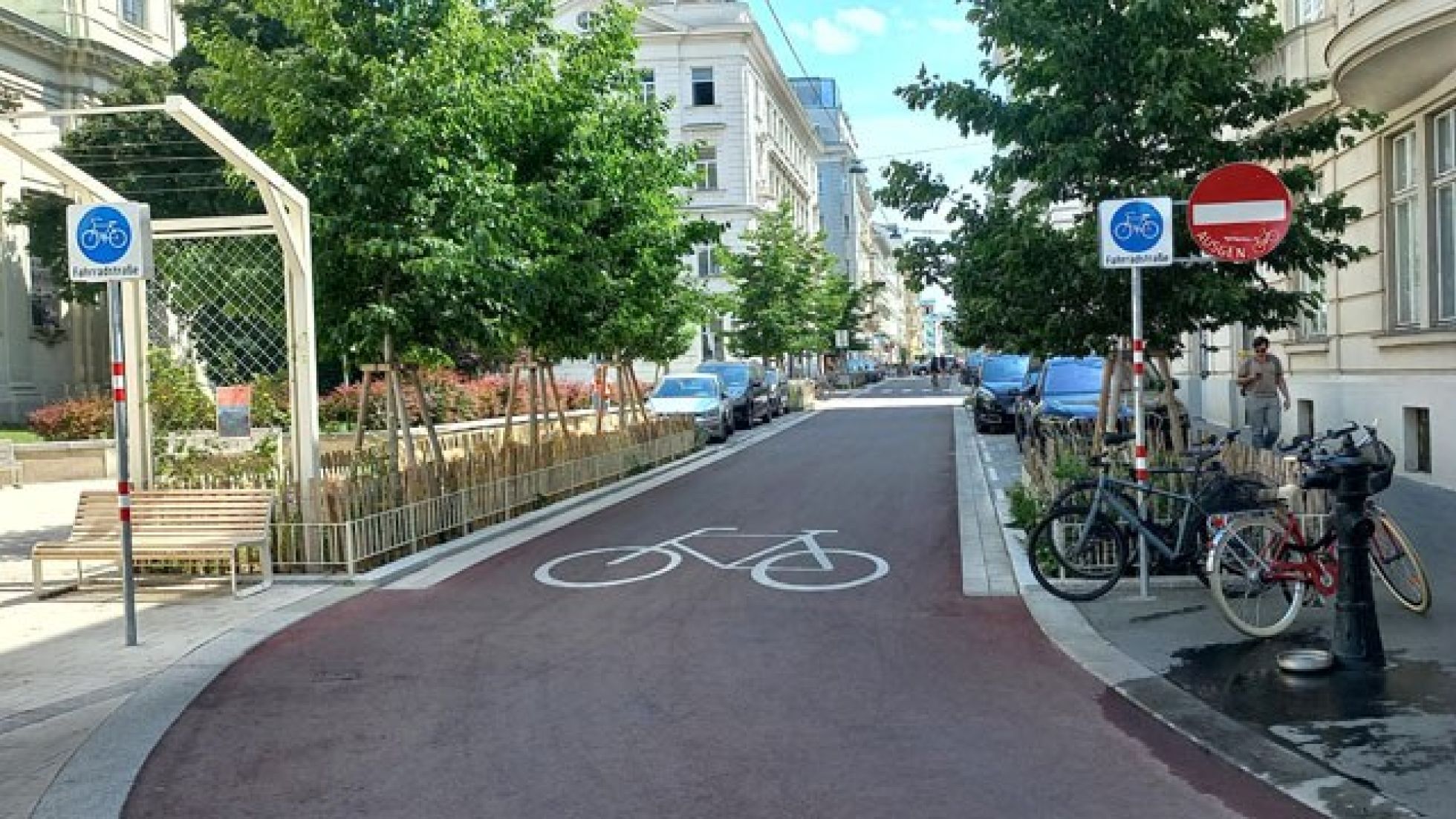 Auf der Fahrbahn ist ein großes Fahrradsymbol aufgezeichnet. Verkehrsschilder links und rechts der Fahrbahn markieren eine Fahrradstraße und "Einfahrt verboten ausgenommen Radverkehr".