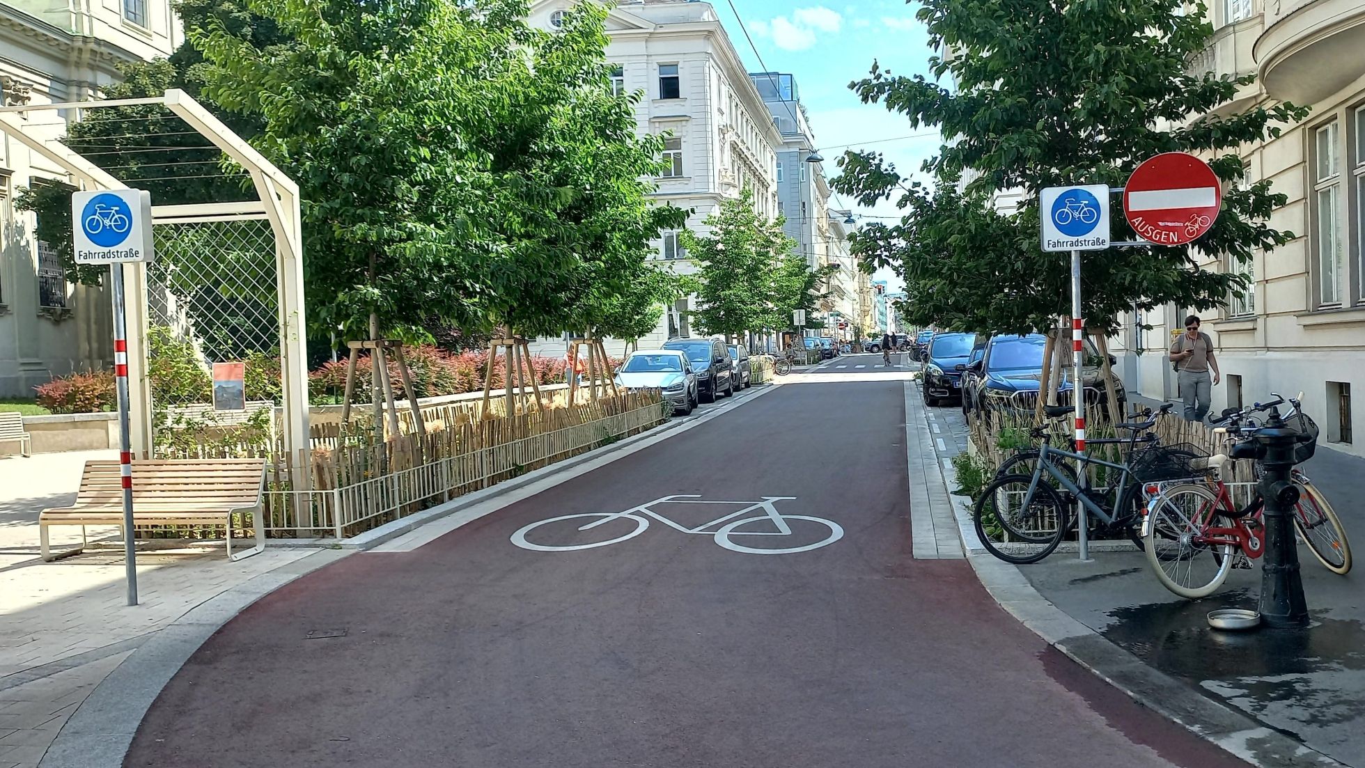 Auf der Fahrbahn ist ein großes Fahrradsymbol aufgezeichnet. Verkehrsschilder links und rechts der Fahrbahn markieren eine Fahrradstraße und "Einfahrt verboten ausgenommen Radverkehr".