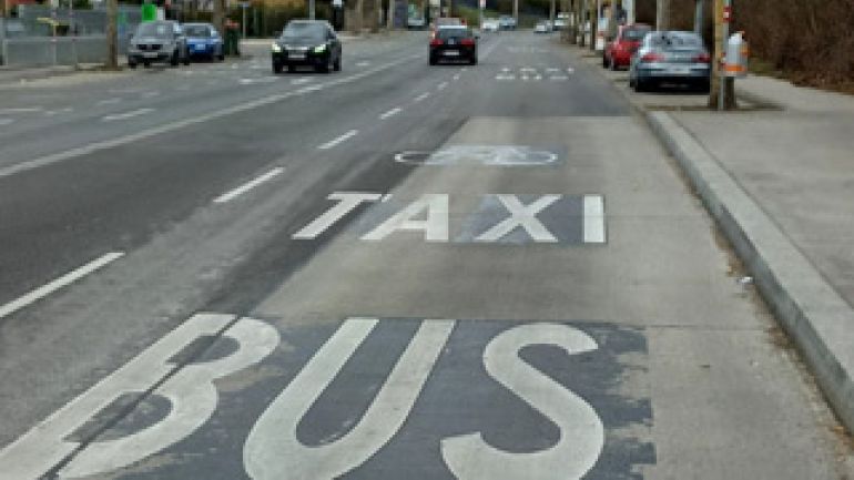 Auf der rechten Fahrspur stehen in Großbuchstaben "Bus" und "Taxi" sowie ein Fahrradpiktogramm.