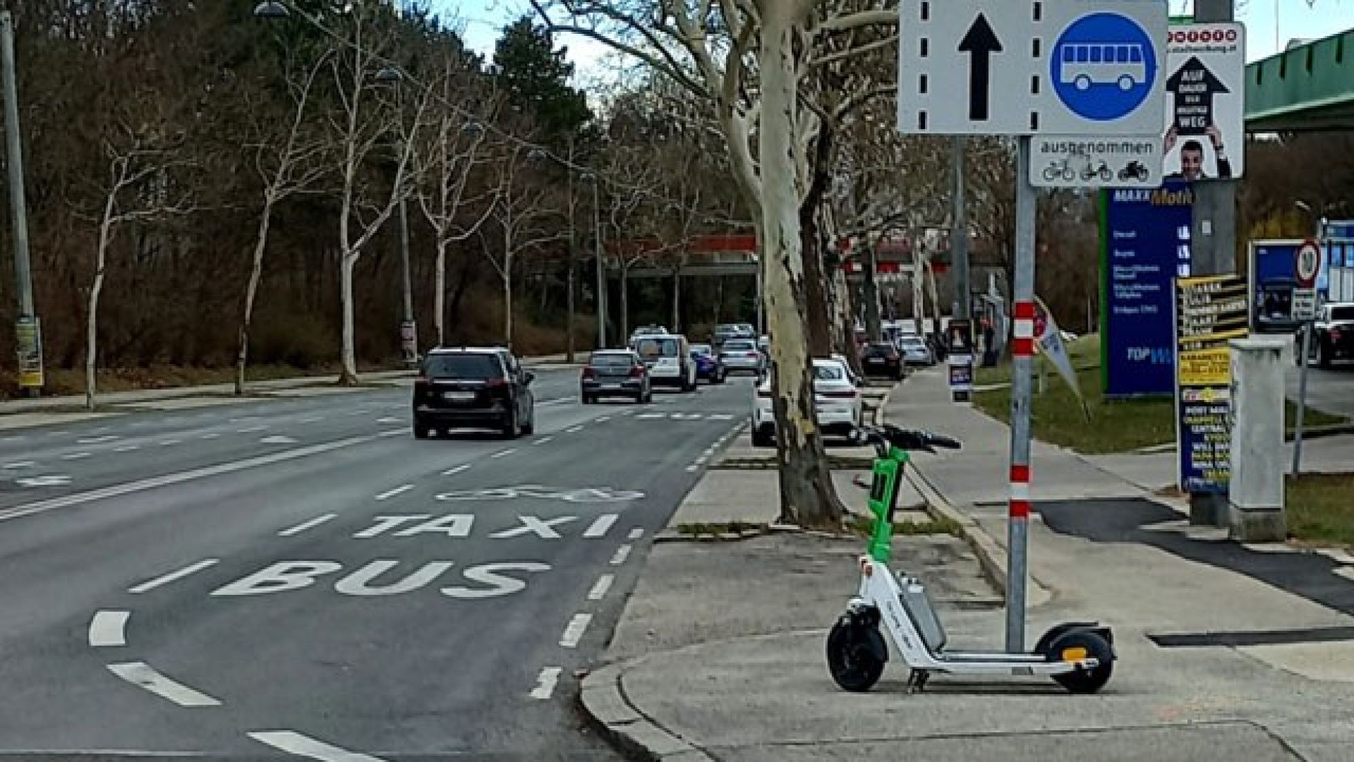 Auf einer mehrspurigen Fahrbahn stehen am rechten Fahrstreifen "Bus", "Taxi" und ein Fahrradpiktogramm am Boden. Rechts davon steht ein Verkehrsschild, das die Busspur kennzeichnet mit Zusatz "ausgenommen Fahrräder und Motorräder".