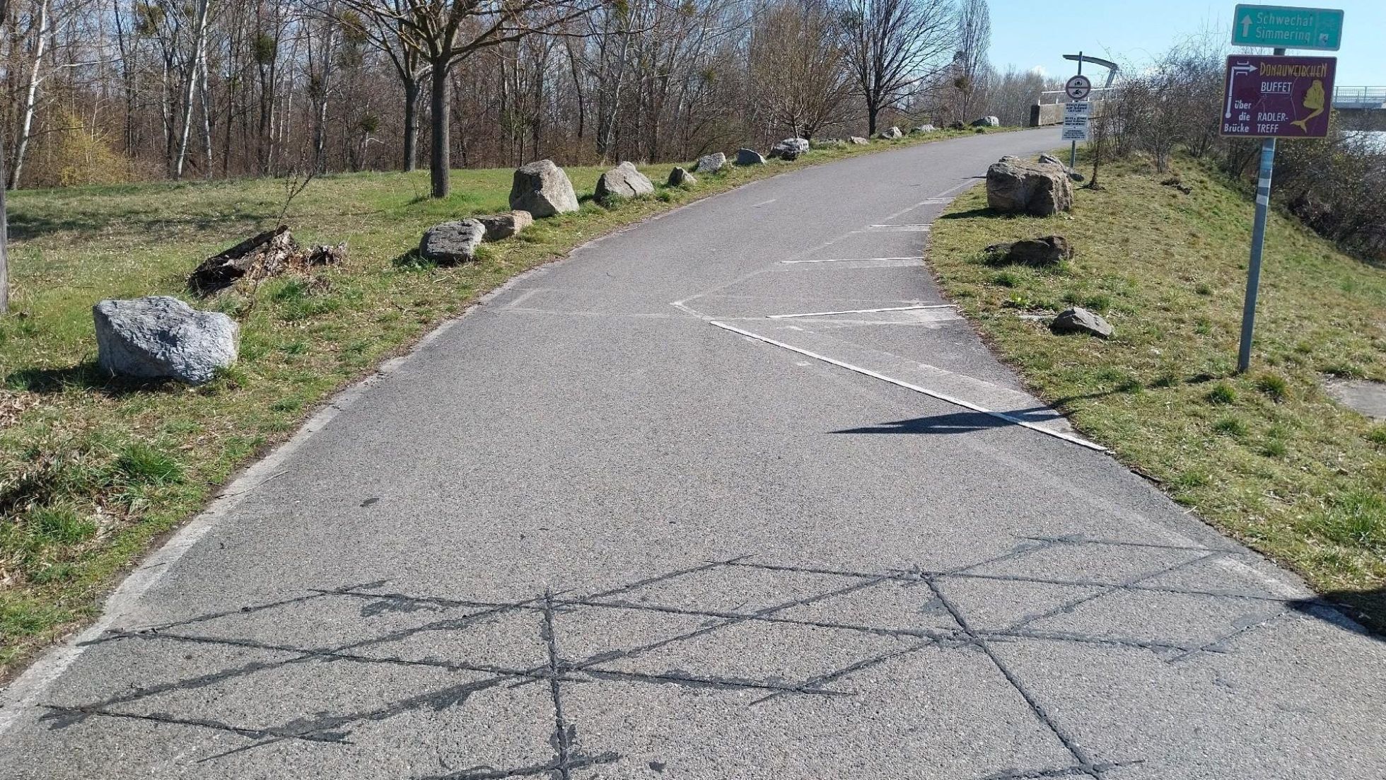 Am Straßenbelag eines Radwegs sind dunkle Linie erkennbar, wo die Sensoren für die Radzählung eingebaut sind.