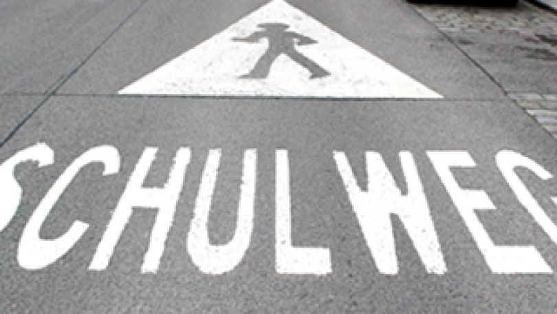 Bodenpiktogramm "Achtung Fußgänger" und Schulwegmarkierung