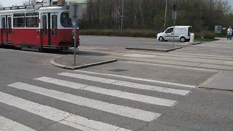Kreuzungsbereich Neilreichgasse - Wienerfeldgasse: Straßenbahn fährt auf Zebrastreifen zu