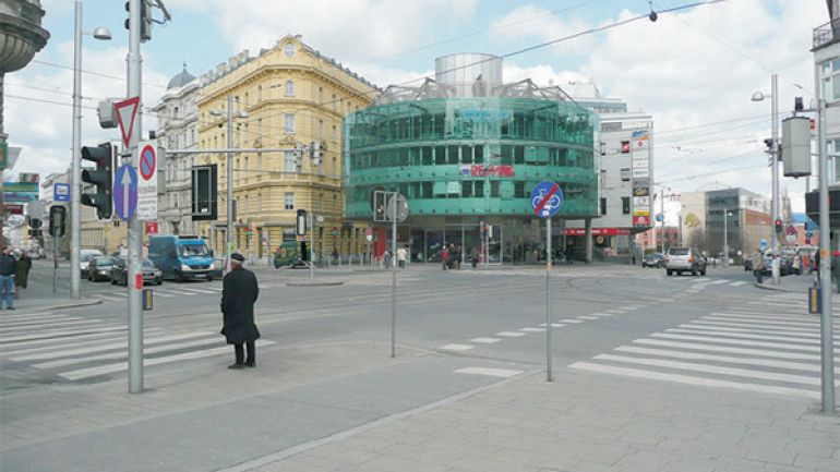 Große Kreuzung vor der Station Rennweg: breite Fahrbahnen, Radweg, Zebrastreifen, Ampeln