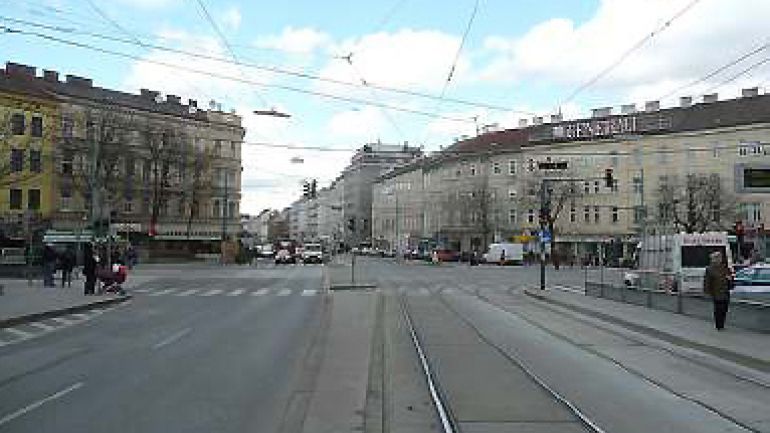Kreuzungsbereich Laxenburger Straße - Quellenstraße: breiter Kreuzungsraum, Fahrstreifen für Kfz, Straßenbahngleise, Ampelanlage