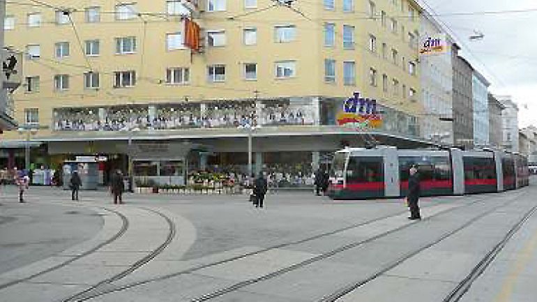 Kreuzungsbereich Favoritenstraße - Quellenstraße: Gleisanlagen, breiter Straßenraum, Straßenbahn biegt in die Fußgängerzone