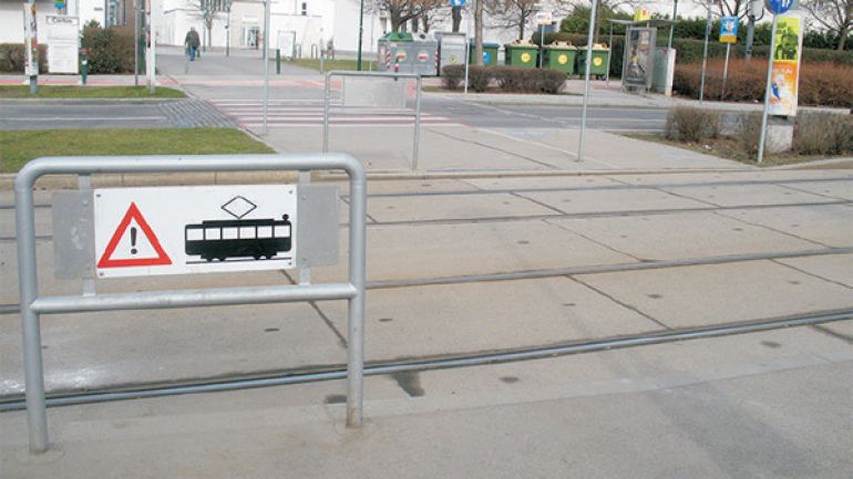 Kreuzungsbereiche Landgutgasse - Humboldtgasse: Breiter Kreuzungsbereich mit gekennzeichnetem Gefahrenbereich beim Gleiskörper und Zebrastreifen über die Fahrbahn