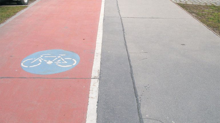 Rot markierter Radweg neben einem Gehweg