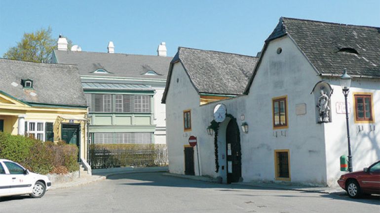 Kreuzungsbereich Eroicagasse - Pfarrplatz: Breiter Platz ohne Bodenmarkierungen oder Ampeln