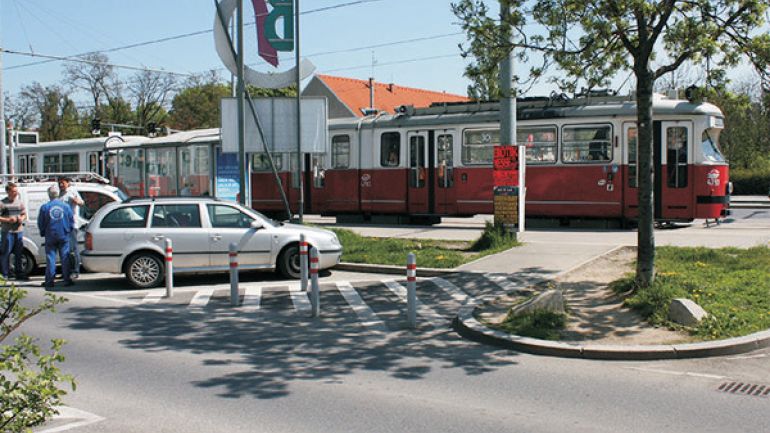 Kreuzungsbereich Brünner Straße - Straßenbahnstation: Kreuzung mit Straßenbahnhaltestelle und parkenden Autos