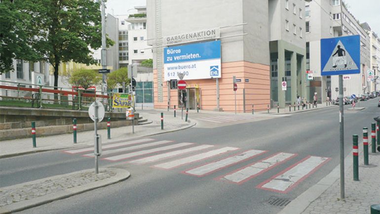 Kreuzungsbereich Apostelgasse - Erdbergstraße: Zebrastreifen über Straße, Verkehrsschilder, Wohnhausanlage