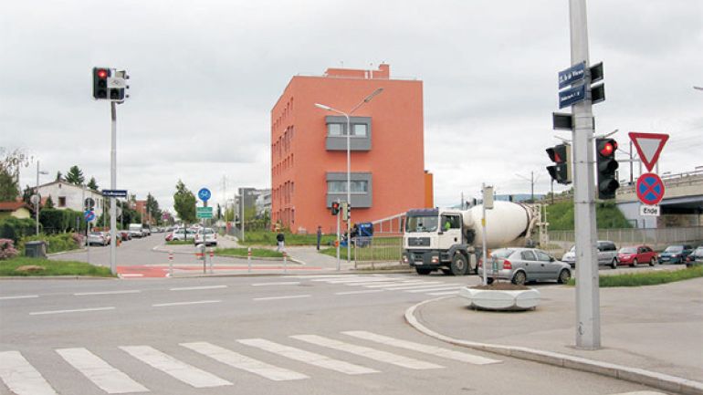 Kreuzungsbereich Erlaaer Straße - Meischlgasse - Carlbergergasse: Kreuzung mit Radweg, Fußgängerinsel, Zebrastreifen und Fußgängerampeln