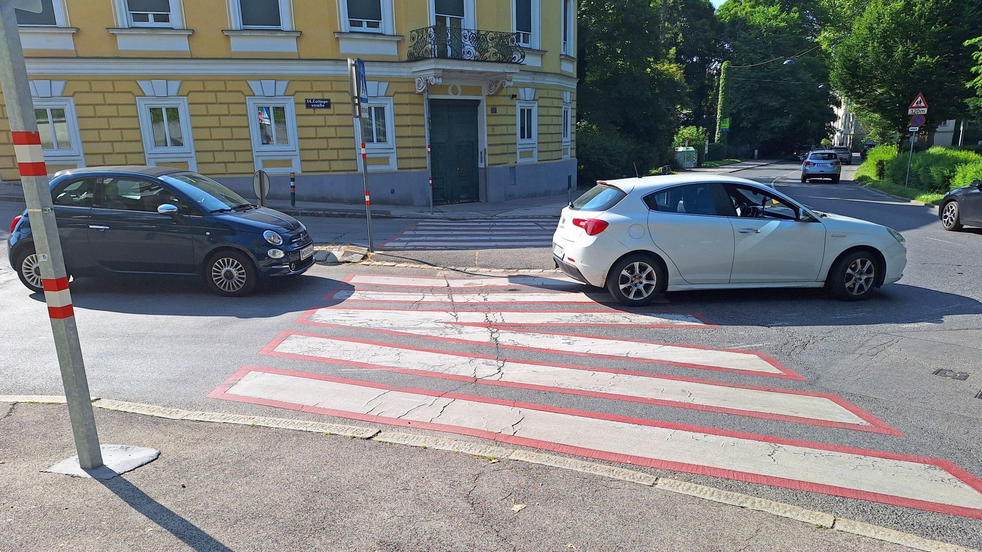 copyright: AUVA Straße mit Zebrastreifen und zwei Autos.