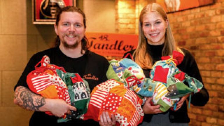 2 Personen halten Geschenksäcke in ihren Händen