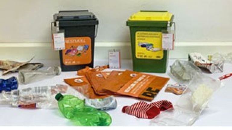 Eine Restmülltonne, eine Plastikmülltonne, davor liegend Plastikflaschen und wiederverwendbare, gefaltete Müllbehältnisse