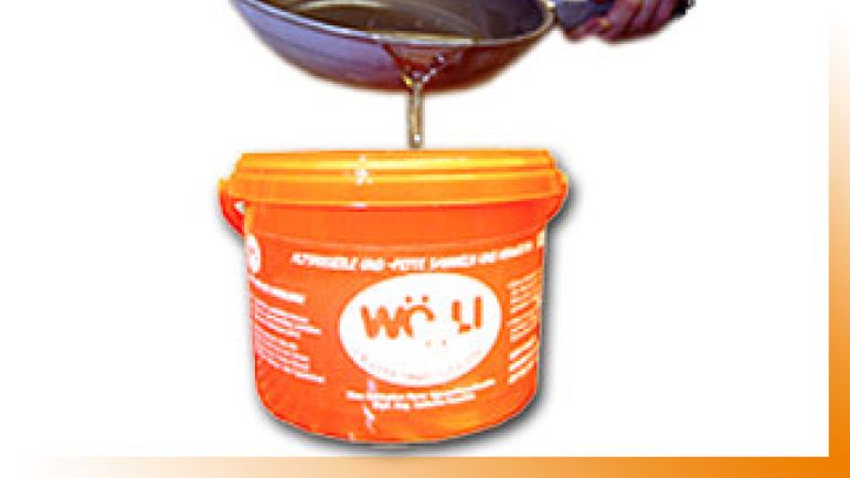 Verbrauchtes Speiseöl wird aus einer Pfanne in den WÖLI geschüttet