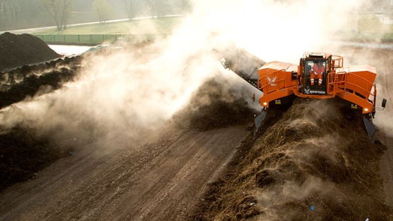 Maschine arbeitet dampfenden Kompost auf