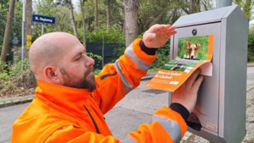 Mitarbeiter der MA 48 beklebt einen Hundekotsackerlspender