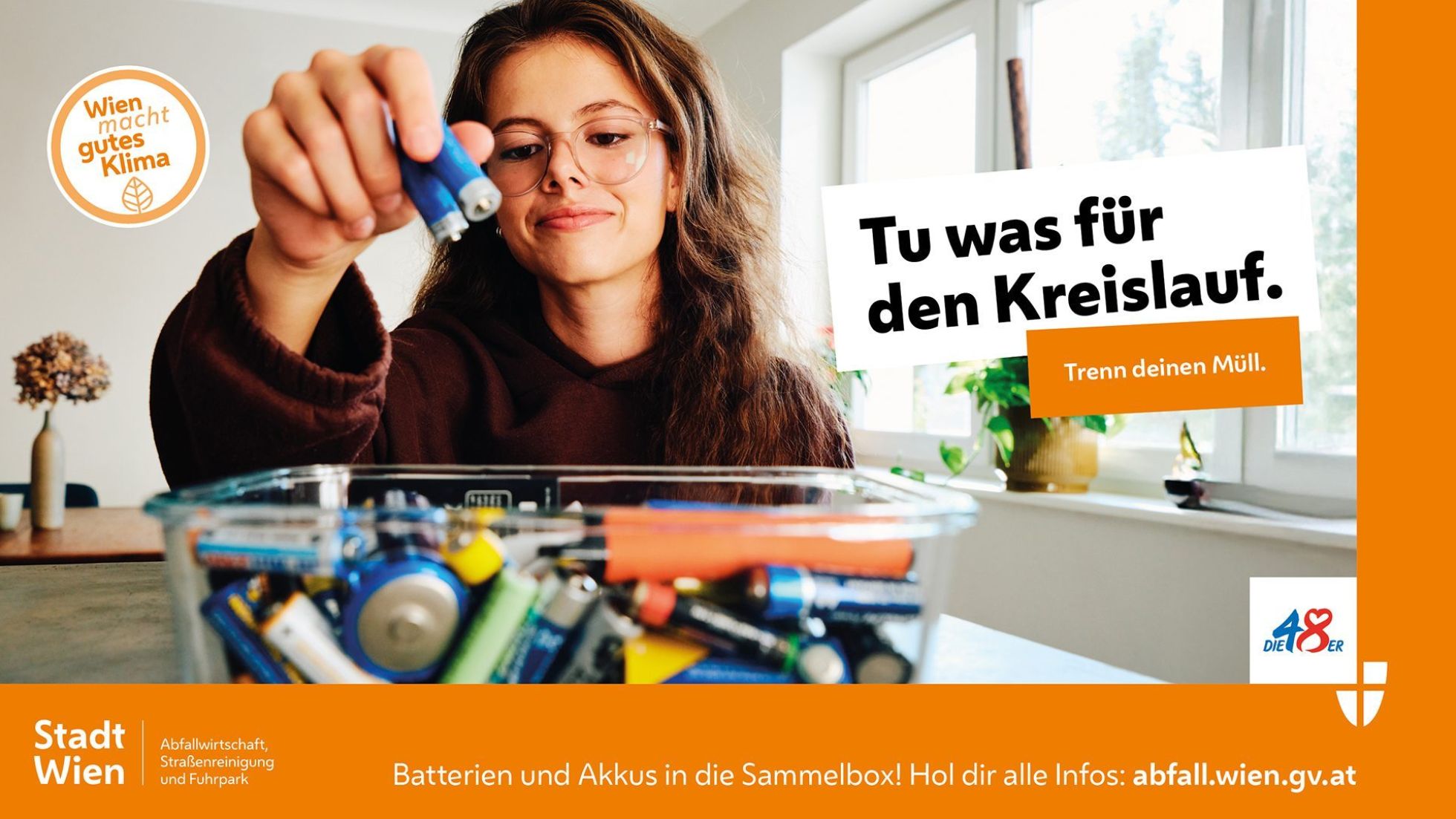 copyright: MA 48 Eine Frau legt Batterien in einen gläsernen Sammelbehälter.