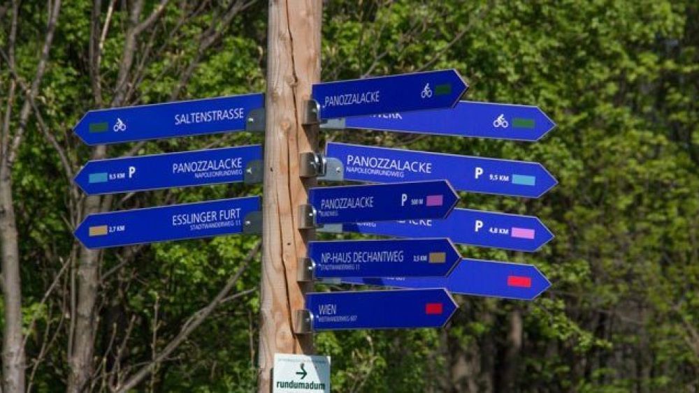 Holzpfosten mit Wegweisern für unterschiedliche Wanderwege in der Lobau
