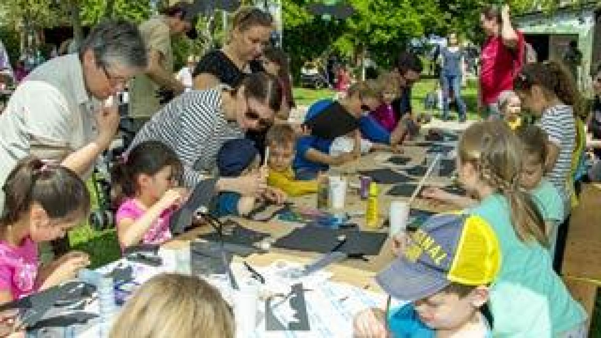 Kinder und Erwachsene basteln an einem Tisch