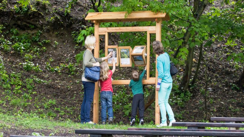 2 Erwachsene und 2 Kinder an einer interaktiven Schautafel