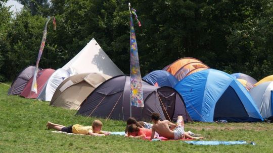 Kinder auf einer Wiese mit Zelten