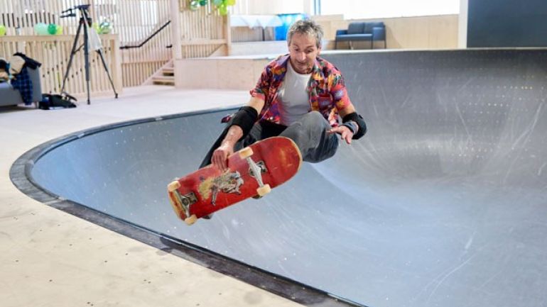 Mann auf Skateboard in der Halfpipe