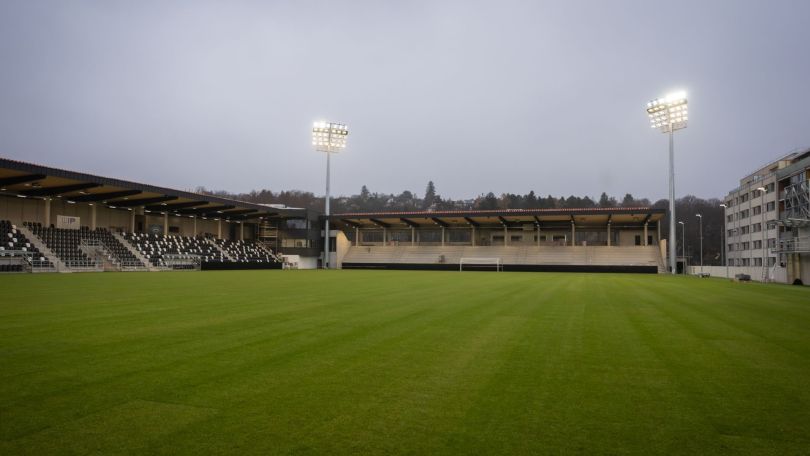 copyright: Stadt Wien / David Bohmann Stadion mit grünem Rasen, Tribüne und Scheinwerfern bei Dämmerung.
