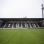 Stadion mit grünem Rasen und einer Tribüne mit der Zahl 1883.
