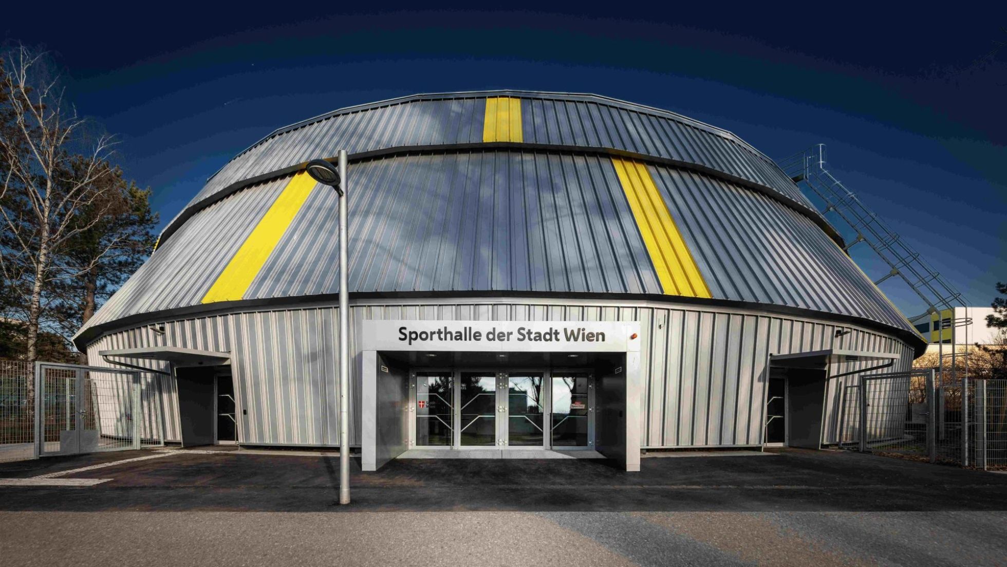 Sporthalle von außen mit Aufschrift "Sporthalle der Stadt Wien"