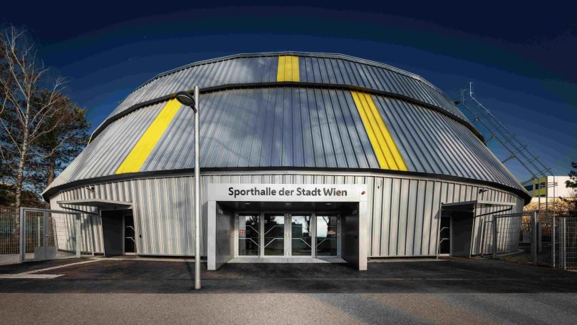 Sporthalle von außen mit Aufschrift "Sporthalle der Stadt Wien"