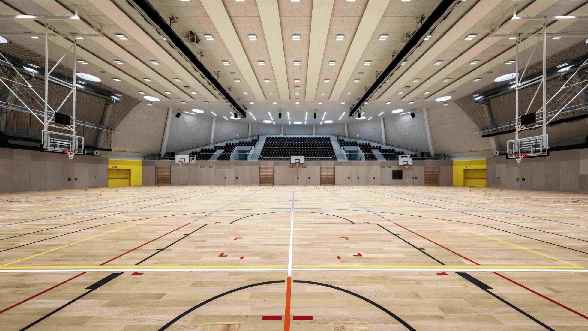copyright: Architekturfotografiewien / Romana Fürnkranz Moderne Sporthalle von innen mit Zuschauertribüne, Beleuchtung und Markierungen am Saalboden