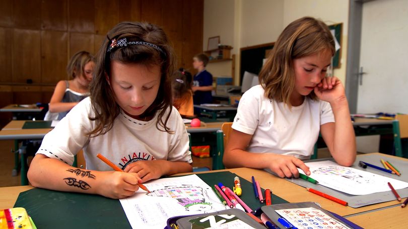 copyright: Bilderbox.com 2 Mädchen malen in einer Schulklasse.