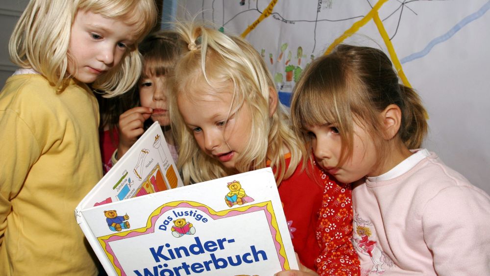 3 Mädchen lesen in einem Buch