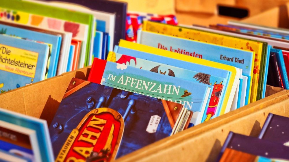 Eine Holzkiste voller bunter Kinderbücher