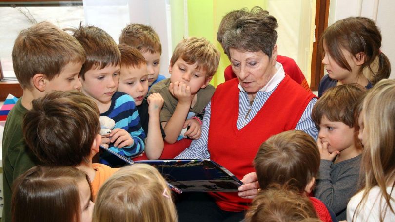 copyright: Stadt Wien/Martin Votava Eine ältere Dame liest Kindern aus einem Buch vor.