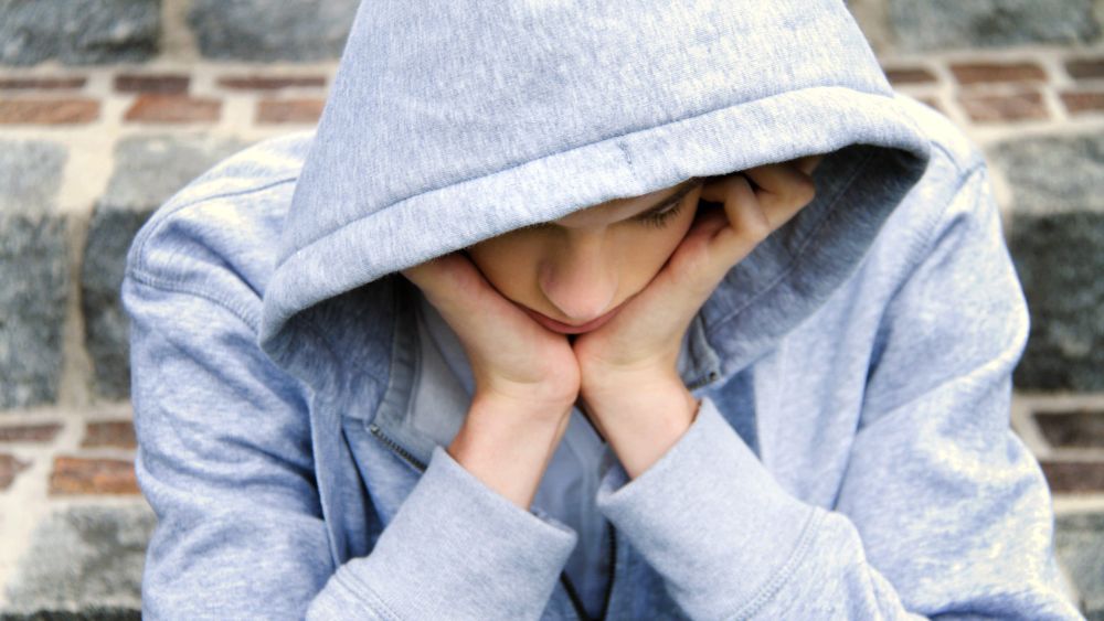 copyright: Erwin Wodicka - Bilderbox.com Junger Mann, der den Kopf in die Hände stützt und zu Boden blickt