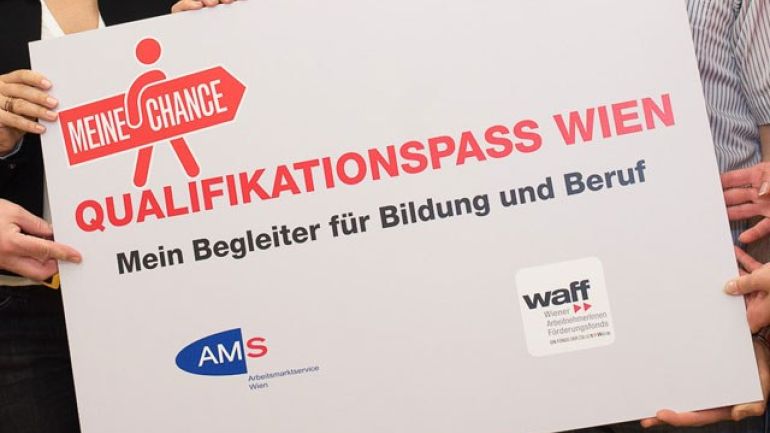 copyright: PID - David Bohmann Mehrere Personen halten ein Schild mit der Aufschrift "Qualifikationspass Wien - Mein Begleiter für Bildung und Beruf"