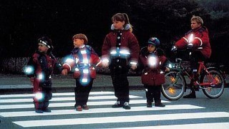 Kinder in Schutzwesten am Zebrastreifen