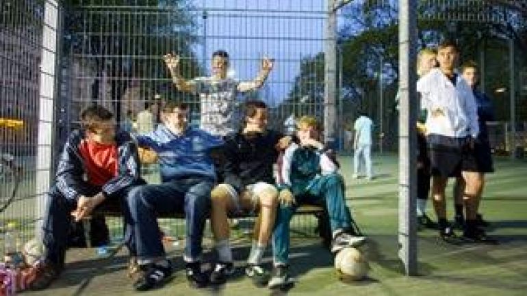 Jugendliche bei einem Fußballkäfig