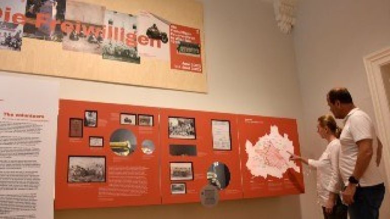 copyright: Stadt Wien - Feuerwehr 2 Menschen sehen sich die Schautafeln einer Ausstellung an