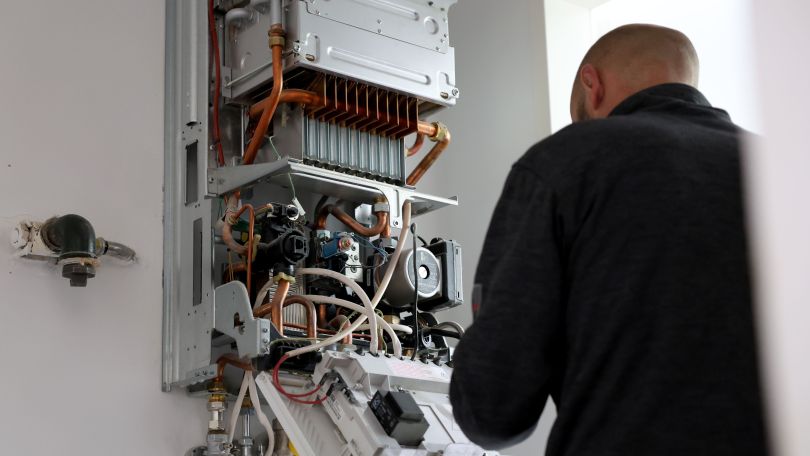 Technician maintains gas boiler