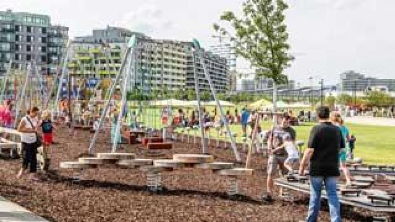 Motorikstationen und Klettergerüste vor neugebauten Wohnungsblocks